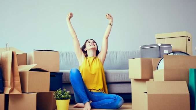 Happy young woman moving to new home - having fun